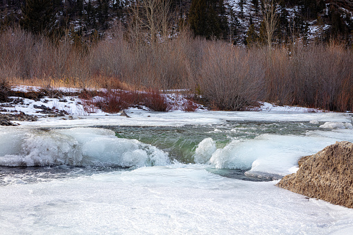 Icy banks of the north fork Shoshone River in Shoshone National Forest of northweset Wyoming wilderness in winter.