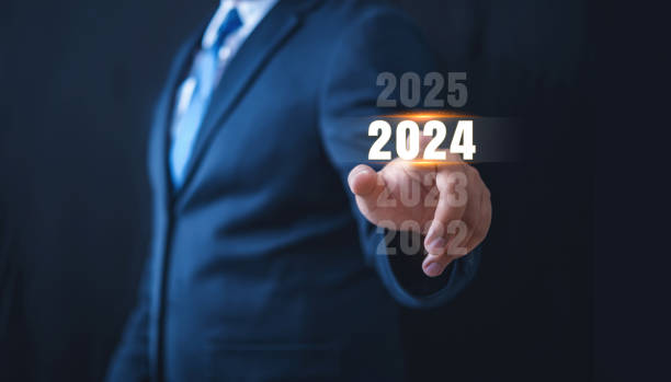 istock Business man in suit touch or select hand pointing on year 2024 text with virtual screen on black background, goal target, change from 2023 to 2024, strategy, investment, business planning, new year concept 1908441447