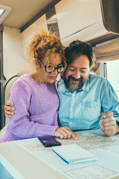 istock couple sitting in camper planning trips, smiling. Adventurous life concept 1908448664