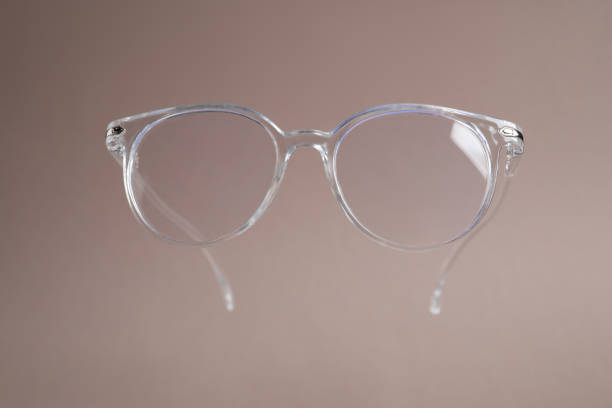 Stylish pair of glasses on pale brown background