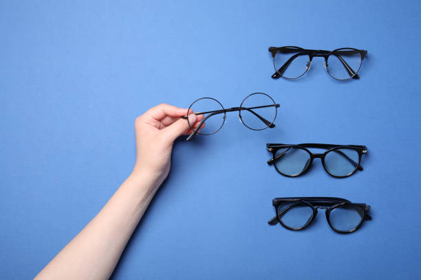 istock Woman with different stylish glasses on blue background, top view 1908452279