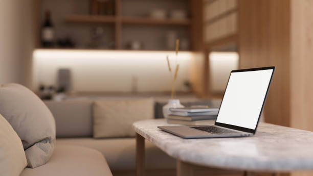 istock Side view image of a white-screen laptop computer on a coffee table in a modern and cosy living room 1908481188
