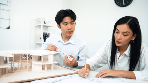 istock Closeup of engineer team working together to measure house model. Immaculate. 1908512492