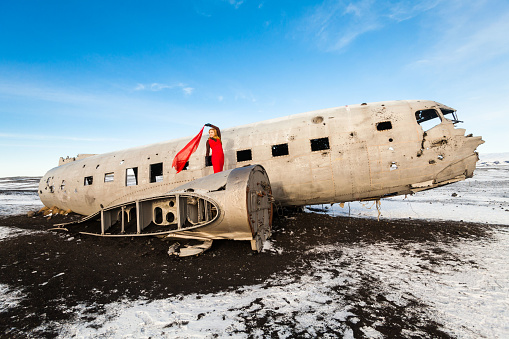 A young woman posing in Solheimasandur the plane wreck view during winter snow