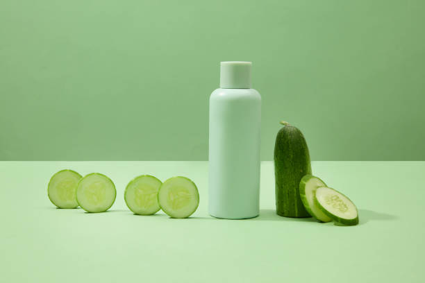 istock Cucumber slices are arranged next to an unlabeled bottle on a minimalist background. The space evokes the idea of a cosmetic advertising scene with natural ingredients. 1908562065