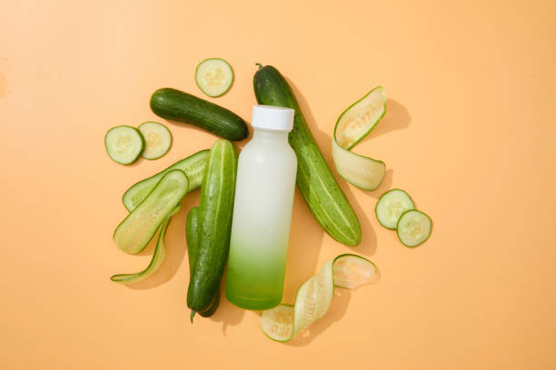 istock Flat lay of an empty bottle with fresh cucumber on a pastel background. Substances in cucumber can soothe irritated skin. Copy space for advertising. 1908562074