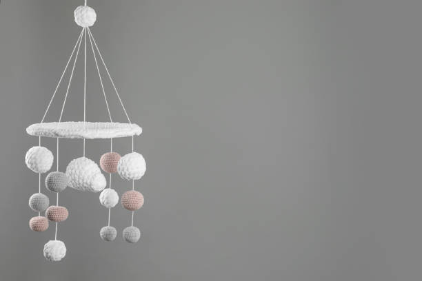 istock Cute baby crib mobile on grey background. Space for text 1908562583