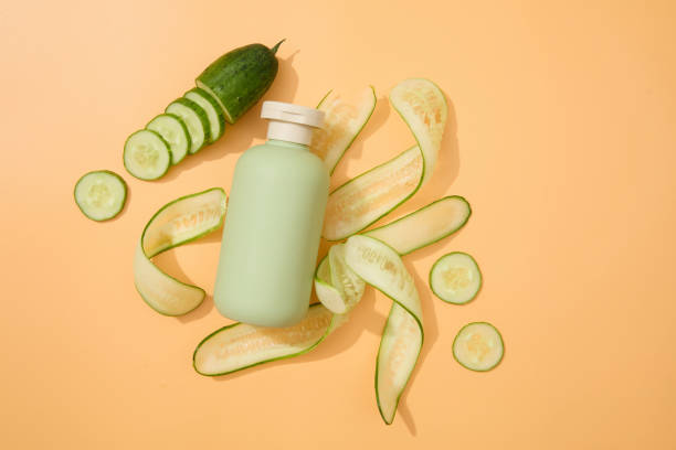 istock Centered in the frame, a cosmetic bottle with fresh cucumber stands on a pastel background. A blank label invites personalized lettering, perfect for cosmetics advertising with copy space. 1908563141