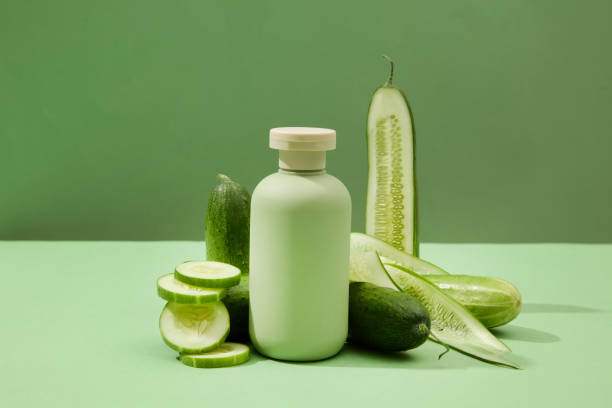 istock On a green background, an unlabeled cosmetic bottle and fresh cucumbers are displayed. Ideal space for advertising beauty products with natural extracts. 1908564211