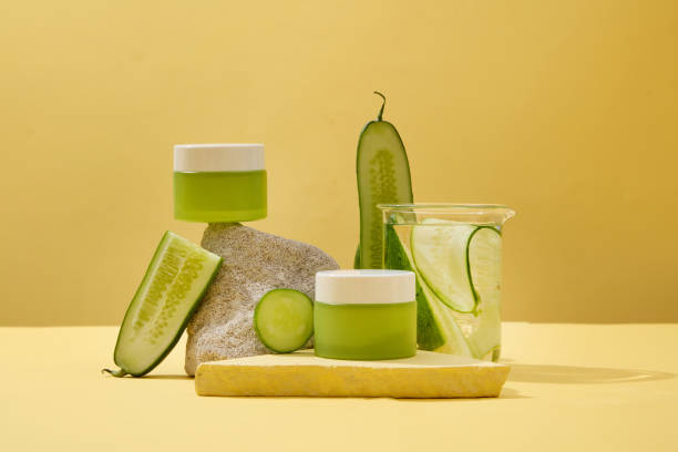 istock Two unlabeled green cosmetic jars and fresh cucumbers are placed on a stone platform with a minimalist background. Advertisement with exquisite cosmetics mockup. 1908569390