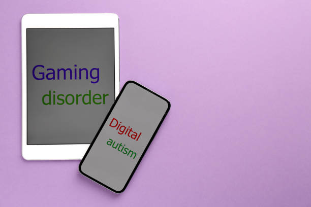 istock Addictive behavior. Tablet, smartphone with phrases Gaming Disorder and Digital Autism on violet background, flat lay. Space for text 1908570966