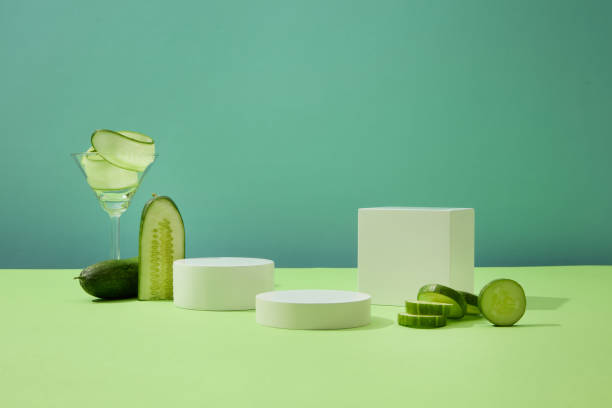 istock Fresh cucumbers are decorated around white platforms, thin cucumber slices inside a cocktail glass. Advertising space with empty podiums displaying products. 1908573599