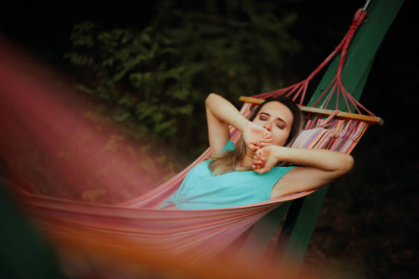 istock Sleepy Woman in a Hammock Yawning and Resting 1908590566