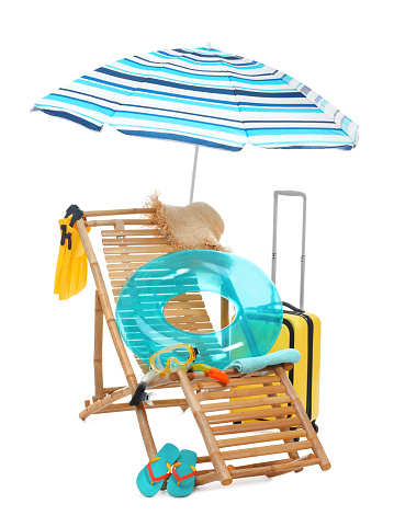 Deck chair, umbrella, suitcase and beach accessories isolated on white