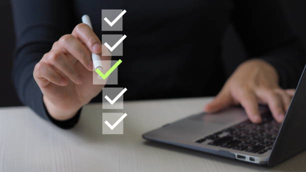istock Businessman using pen to tick correct sign mark on virtual checklist for quality control and assurance of ISO concept. 1908648899