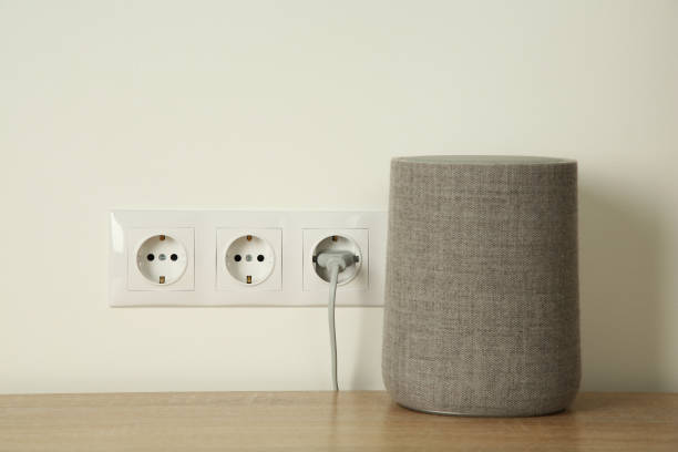 istock Electrical plug in socket near loudspeaker on wooden table indoors 1908687604