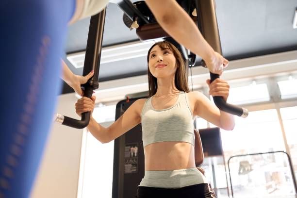 istock Woman training her chest muscles with a pectoral fly machine 1908690767