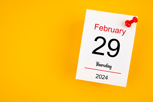 February 29th calendar for February 29 and wooden push pin on yellow background.
