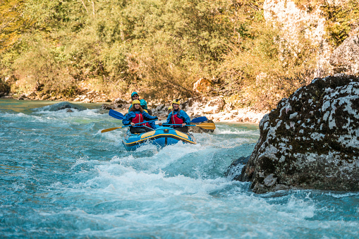A family outing turns into an adventure with a Caucasian mother and her kids learning from a rafting guide amidst the beauty of a winding river.