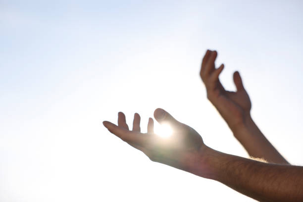 istock Feeling freedom. Man reaching for sky on sunny day, closeup of hands 1908714897