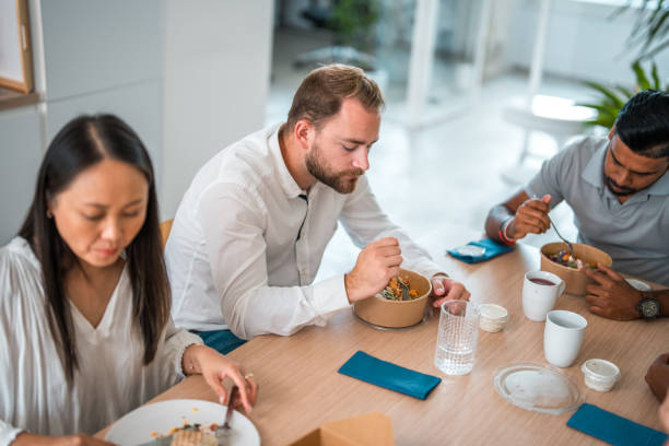 istock Mixed-Race Office Colleagues Eating A Meal 1908717053