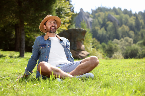 Feeling freedom. Smiling man enjoying nature on green grass outdoors