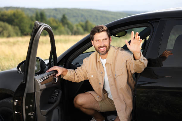 istock Enjoying trip. Happy bearded man waving in car 1908717598