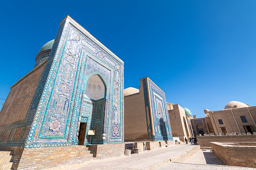 JUNE 24, 2023, SAMARKAND, UZBEKISTAN: Symmetrical decorative ornament of entrance to the tomb and open door in Shah-I-Zinda, a memorial complex, necropolis in Samarkand, Uzbekistan