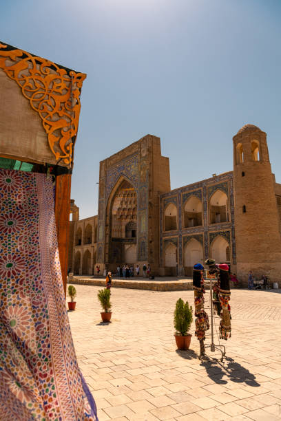 istock Beautiful ethnic fabrics waving with the wind next to ancient madrasah, Bukhara 1908723469