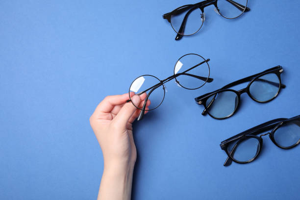 istock Woman with different stylish glasses on blue background, top view 1908734469