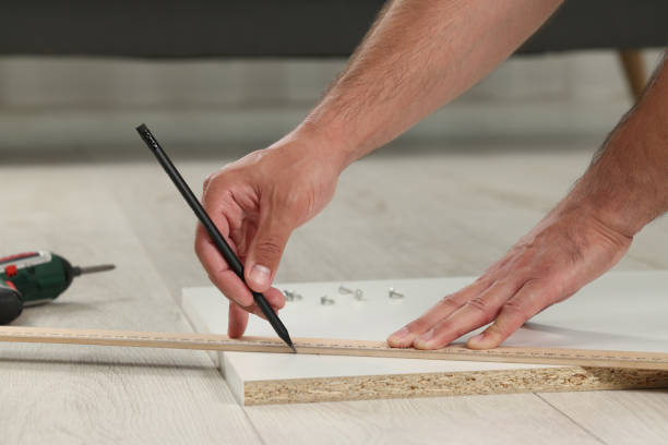 istock Man making mark on white board indoors, closeup. Furniture assembly 1908736025