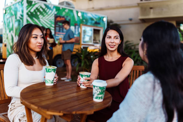 Three young women sit at outdoor table for lunch
