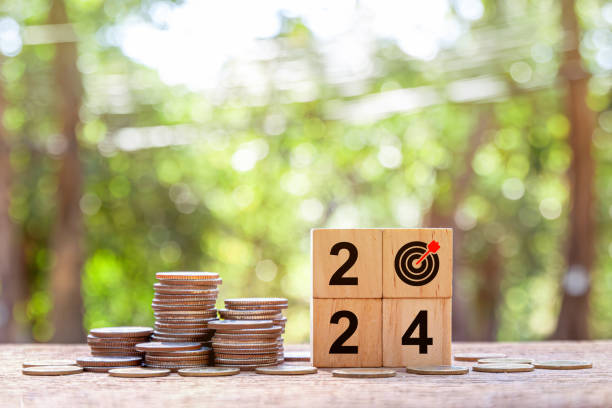 istock Close up stack of coin and 2024 wooden text block with green backgound 1908777000