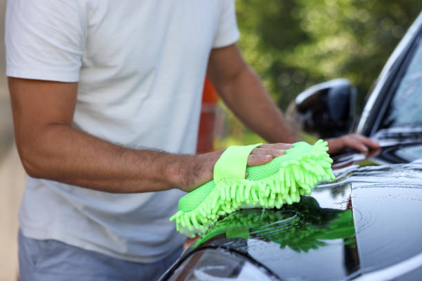 Man washing car with sponge outdoors, closeup