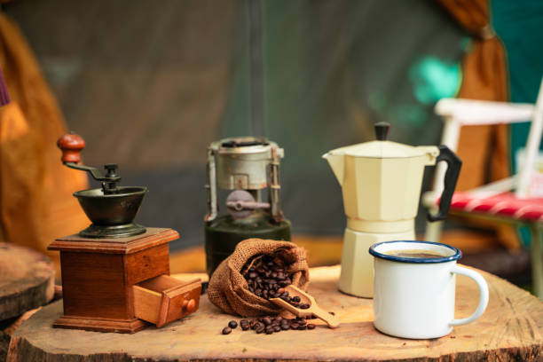 selective focus of vintage coffee set on the old wooden table in front of the retro cabin tent, antique oil lamp, retro chairs, group of camping tents, and soft focus. - lantern lamp hurricane old 뉴스 사진 이미지