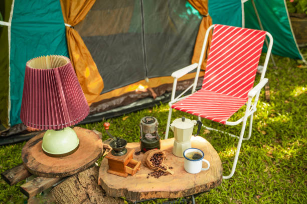 selective focus of vintage coffee set on the old wooden table in front of the retro cabin tent, antique oil lamp, retro chairs, group of camping tents, and soft focus. - lantern lamp hurricane old 뉴스 사진 이미지