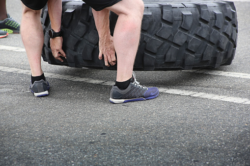 A view of a person lifting a giant tire, as an exercise routine.