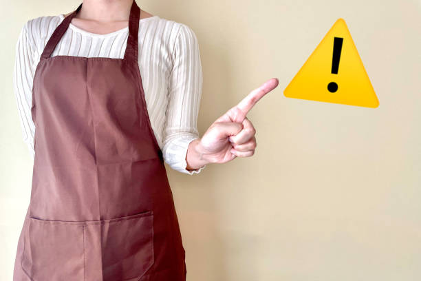 注意を喚起するエプロン姿の女性 - 注意 ストックフォトと画像
