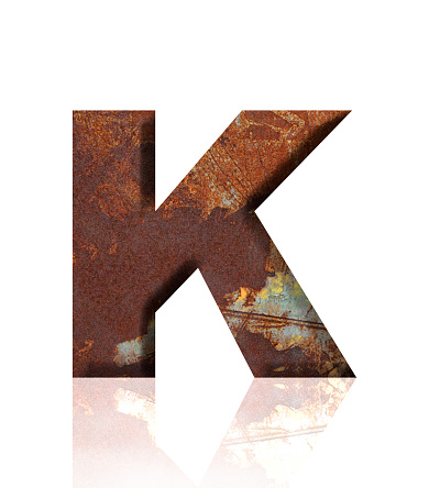Close-up of three-dimensional rusty metal alphabet letter K on white background.