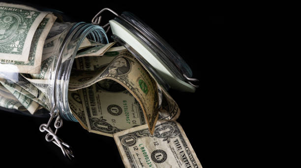 Clear glass jar with 1 US dollar bills on a  black background