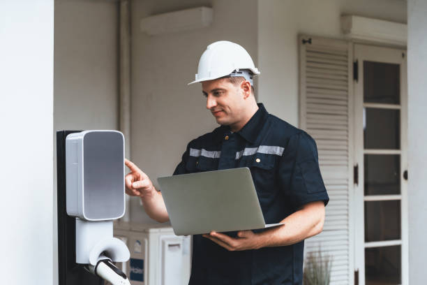 istock Qualified technician working with laptop for home EV station. Synchronos 1908950547