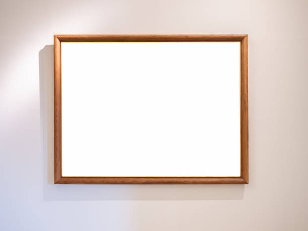 istock Mockup white blank space in thin wooden square picture frame, horizontal style, isolated. Empty single vintage brown rectangular simple photo frame hanging on white wall background with warm light. 1908961095