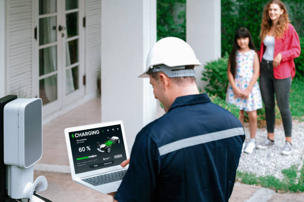 Qualified technician working with laptop for home EV station. Synchronos