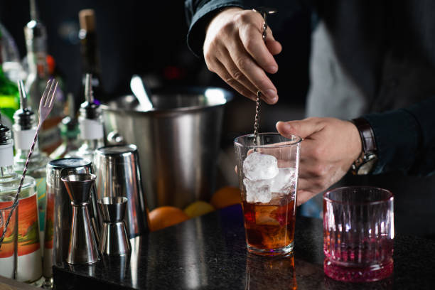 istock Bartender mixing Negroni cocktail with long stirring metal spoon 1909003031