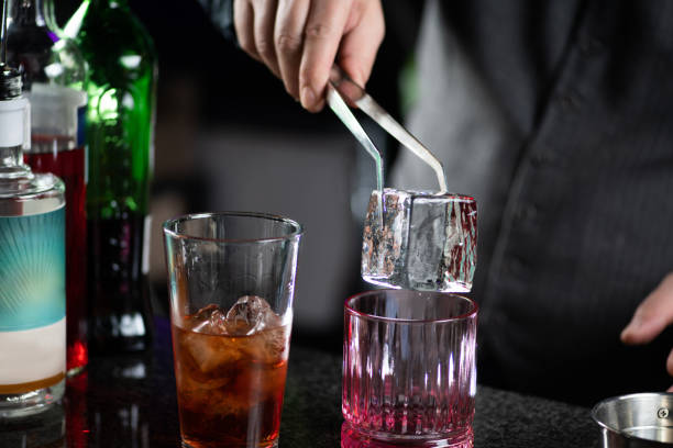 istock Barman Adds Giant Ice Cube to Negroni Cocktail 1909003569