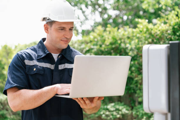 istock Qualified technician working with laptop for home EV station. Synchronos 1909013813