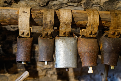collection of vintage old bells with leather belt for goats sheep cows in the countryside of France