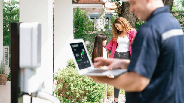 istock Qualified technician working with laptop for home EV station. Synchronos 1909024093