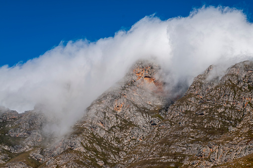 Dramatic clouds and mountains, ragged peaks in natural landscape in the Outeniqua mountains in the fynbos region of the western cape