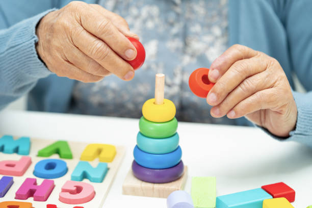 istock Alzheimer disease AD, Asian elderly woman patient suffering from dementia learn practical motor skills rehabilitation. 1909025676